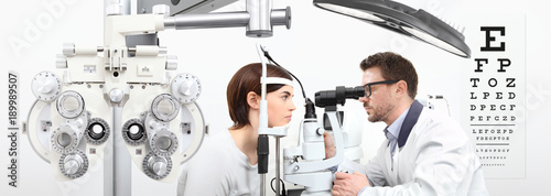 Fotografía optometrist doing eyesight with woman patient measurement with slit lamp on whit