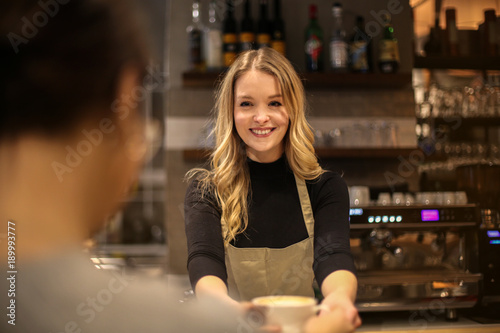 Fotomural Smiling waitress serving a hot drink