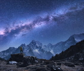 Wall Mural - space with milky way and mountains. standing man on the stone, mountains and starry sky at night in 