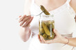 Pregnant woman holding jar of pickles - pregnancy food craving concept