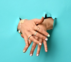 Wall Mural - Beautiful woman hands with yellow pink white pattern nail polish and silver stacking rings and bracelets