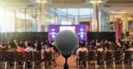 Microphone over the Abstract blurred photo of conference hall or seminar room with Speakers on the stage and attendee background, Business meeting concept