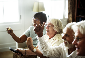 Senior people watching televison together