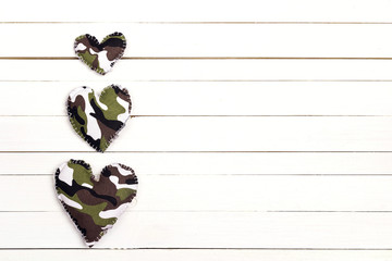 Wall Mural - Military hearts on a white wooden background with copy space.