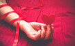 © googibga - Paper Heart in the hand  on red bed background. holding heart,sexy valentine concept