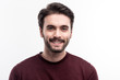 © Viacheslav Yakobchuk - Epitome of masculinity. The portrait of a handsome dark-haired bristled young man in a burgundy sweater smiling at the camera while posing against a white background
