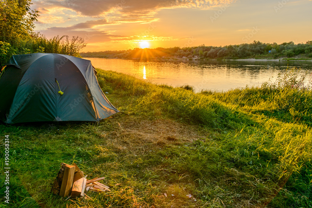 Camping tent in a camping on the river bank - obrazy, fototapety, plakaty 
