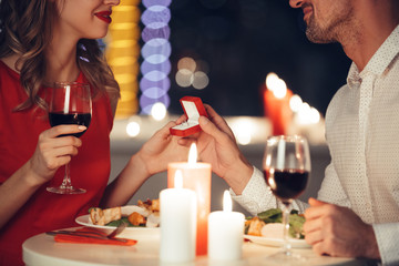 Wall Mural - Cropped photo of young man giving an engagement ring to his woman