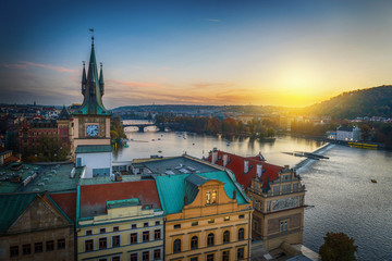 Wall Mural - Evening in Prague. View of the roofs of houses and the river Vltava. Czech Republic.