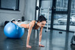 © LIGHTFIELD STUDIOS - young sporty woman doing plank with legs on fitball at gym