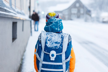 Poster - Happy kid boy having fun with snow on way to school