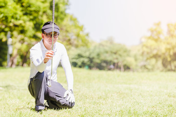 Wall Mural - Asian men playing golf. men play golf while standing on field