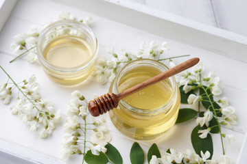 Wall Mural - White wooden tray with sweet honey jar and spring acacia blossoms, top view