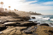 Eroded rock formations and cliffs on a hazy morning at Windansea Beach in La Jolla, California.