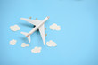 Flat lay design of travel concept with plane and cloud on blue background with copy space.