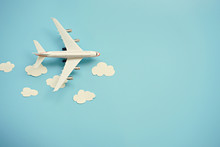 Flat Lay Design Of Travel Concept With Plane And Cloud On Blue Background With Copy Space.