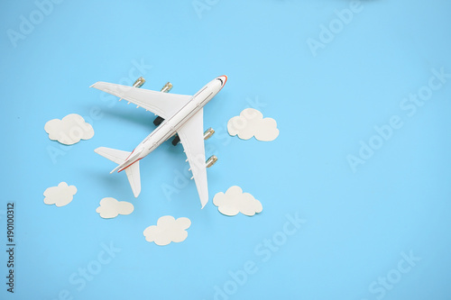 Fotomural Flat lay design of travel concept with plane and cloud on blue background with copy space