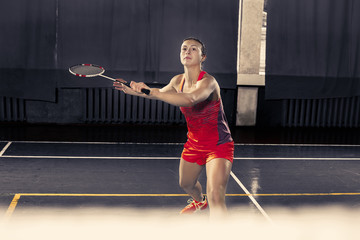 Wall Mural - Young woman playing badminton at gym