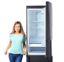 Wall Mural - Woman showing empty pockets near refrigerator on white background