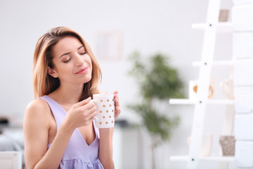 Poster - Beautiful young woman with cup of tea relaxing at home