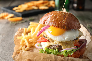 Canvas Print - Tasty burger with fried egg on table, closeup