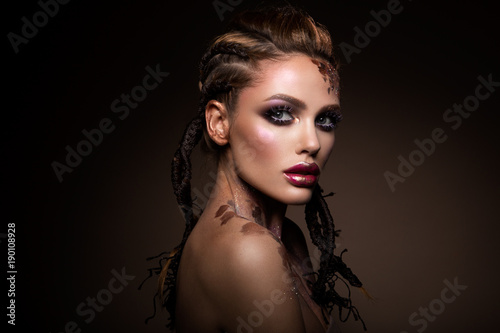 Poster Fashion model with bright makeup and colorful glitter and sparkles on her face a