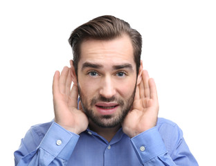 Young man with hearing problem on white background