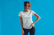 © kanashkin - Attractive woman in a white t-shirt stands on a blue background. Mock-up.