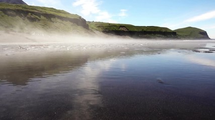 Wall Mural - The fog floats on the rocky shore of the sea