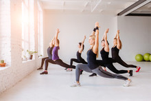 Group Of Women Doing Yoga, Pilates And Fitness And Exercise Indoors In White Loft Interior Studio.