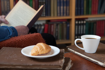 Sweet moments of relaxation with books and a cup of coffee. Vintage books, glasses, chair, library, man