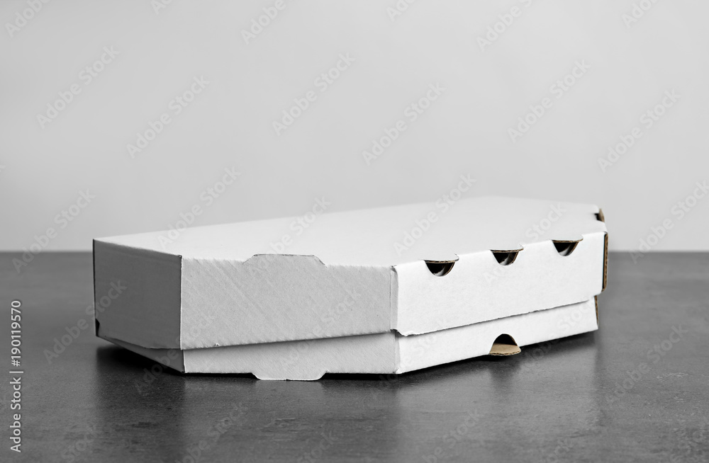Cardboard box on table against white background. Mockup for design