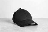 Fototapeta Mapy - Black cap on table against white background. Mockup for design