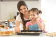 © Africa Studio - Mother and daughter near baking tray with cookie dough indoors