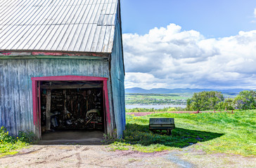 Wall Mural - Blue painted old vintage shed overlooking river in summer landscape field in countryside