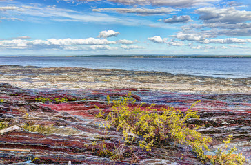 Wall Mural - Landscape view of Saint Lawrence river from Ile D'Orleans, Quebec, Canada in summer with red rocks