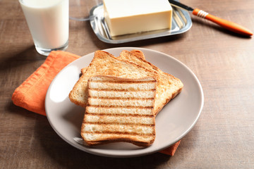 Plate with toasted bread on table