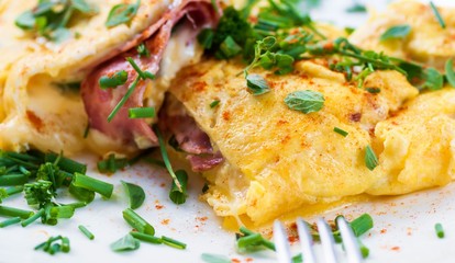 Egg omelette with ham and cheese sprinkled with chive.