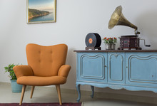 Vintage Interior Of Retro Orange Armchair, Vintage Wooden Light Blue Sideboard, Old Phonograph (gramophone), Vinyl Records On Background Of Beige Wall, Tiled Porcelain Floor, And Red Carpet