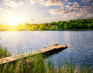 Wall Mural - pier for fishing on the lake under setting sun