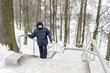 An elderly retired man with a wand climbs the marble staircase in the park. Holds on the railing.  Moscow, Tsaritsyno.