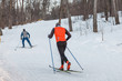 Two cross-country skiers training on a cross-country ski run in the forest