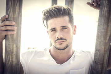 Attractive man in urban setting in front of big metal structure