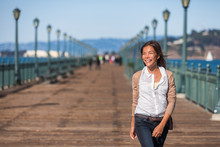 San Francisco Travel Lifestyle Woman Walking Happy On Pier. Asian Girl Smiling Relaxing In Harbor City In USA.