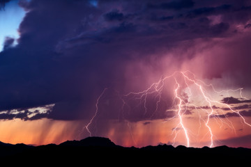 Wall Mural - lightning strikes from a monsoon thunderstorm at sunset in the arizona desert