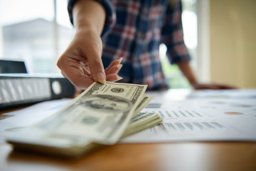 Young business woman hand check dollar banknote. Planning concept.