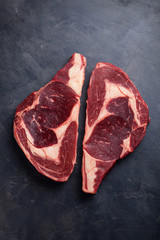 Poster - raw fresh marbled meat steak ribeye black angus on black marble background. beef with spices on a da