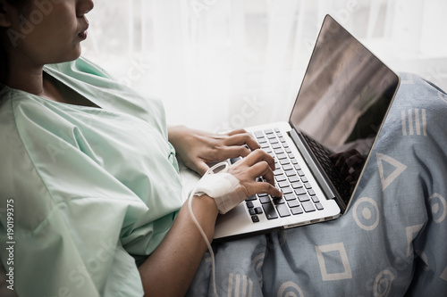 Plakat Chora kobieta pracuje z laptopem w szpitalu.