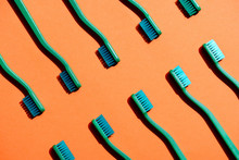 Minimalistic Background With Green Toothbrushes, On Orange