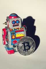 Wall Mural - vintage tin toy robot with bitcoin coin, cryptocurrency mining and investing concept